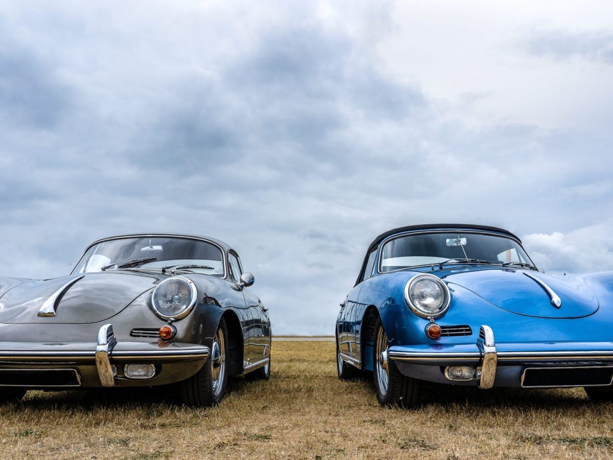 A closeup shot of grey and blue cars put next to each other under a cloudy sky